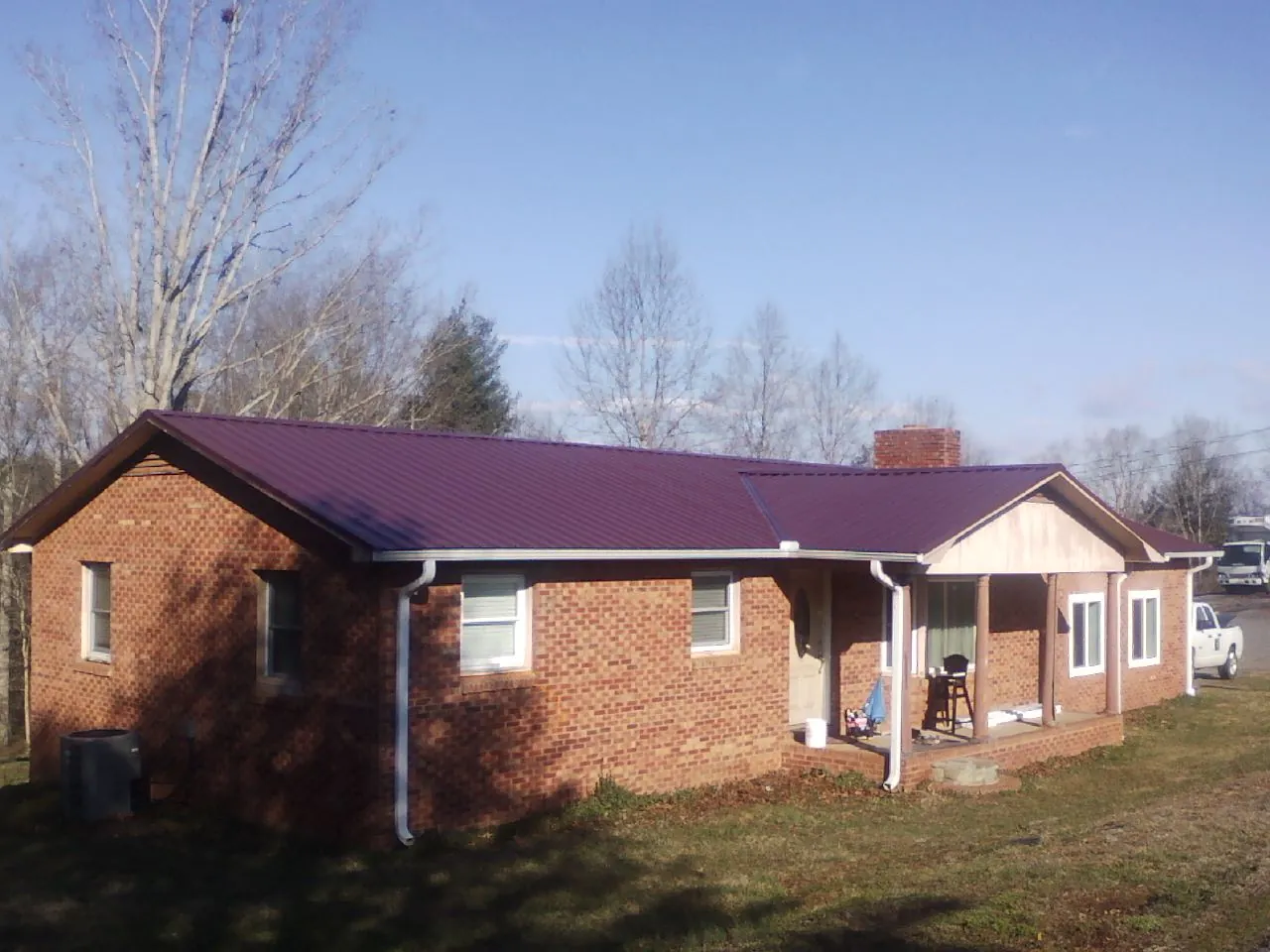 Burgundy metal roof on a brick ranch home with a new addition in Somerset
